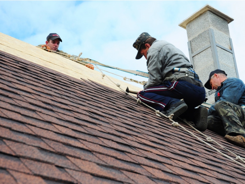 Two men roofing who use AccuLynx, the best roofing software