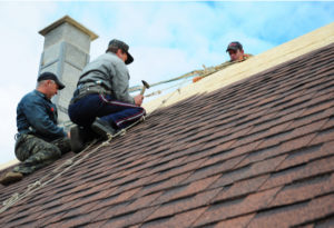 A roofing crew replaces a roof on a home.