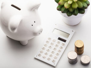 Image of a money, calculator, and piggy bank.