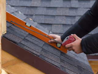 Man measuring a roof.