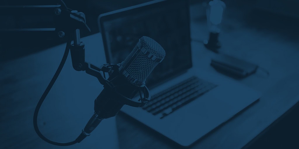 Home studio podcast interior. Microphone, laptop and on air lamp on the table, close-up.